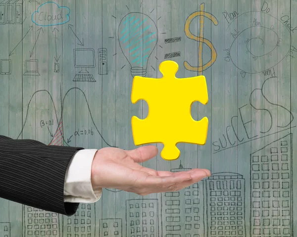 Man hand showing one 3D gold jigsaw puzzle piece — Stockfoto