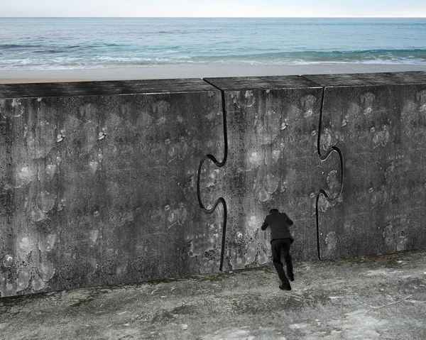 Man pushing huge puzzle door of concrete wall — Stock fotografie