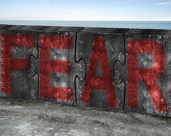 Red fear word on huge concrete puzzles with sea background — 图库照片