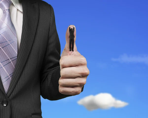 Businessman hanging on another big thumb with sky — ストック写真