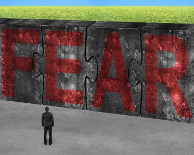 Man facing red fear word on huge concrete puzzles connected