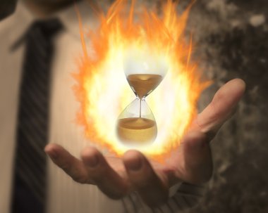 Hourglass with fire ball in business man's hand clipart
