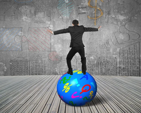 Businessman balancing on the colorful symbols ball — Stock Photo, Image