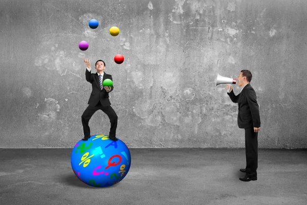 Αφεντικό χρησιμοποιώντας ομιλητής φωνάζοντας επιχειρηματία να ισορροπήσουν στην σφαίρα juggl — Φωτογραφία Αρχείου