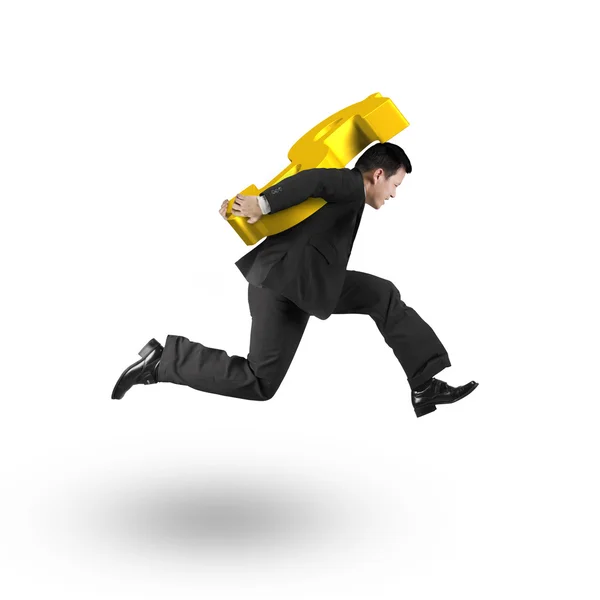 Jumping businessman carrying 3D golden dollar sign — Stock fotografie