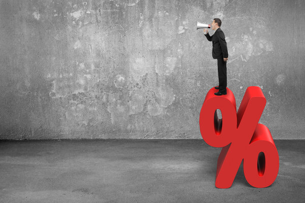 Бизнесмен с помощью громкоговорителя кричит на красный знак процента
