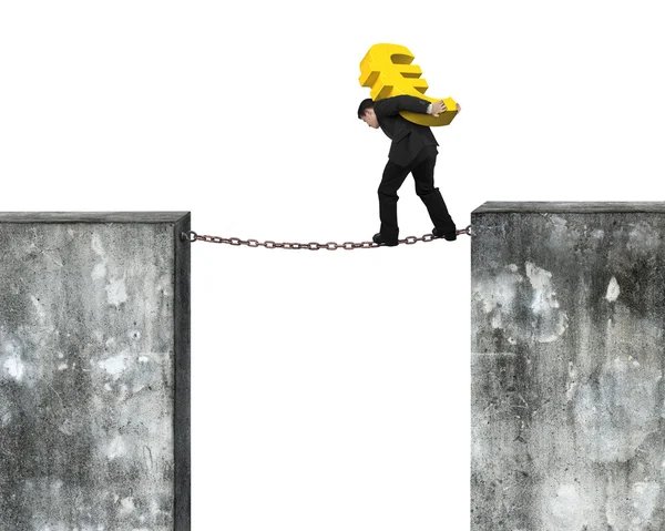 Empresario que lleva el signo dorado del euro balanceándose en la cadena oxidada — Foto de Stock