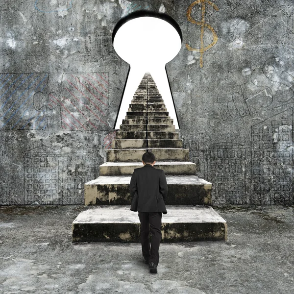 Man climbing old concrete stairs toward keyhole — Stock Photo, Image