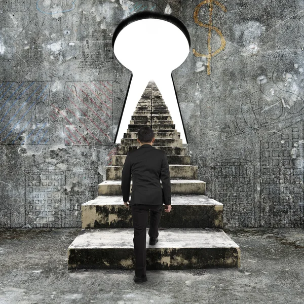 Businessman climbing the old concrete stairs toward keyhole — Stock Photo, Image