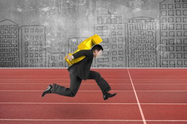 Businessman carrying golden dollar sign running on track