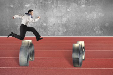 Man jumping over currency symbol obstacles on track