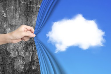 Woman hand pulling white cloud blue curtain covering old wall