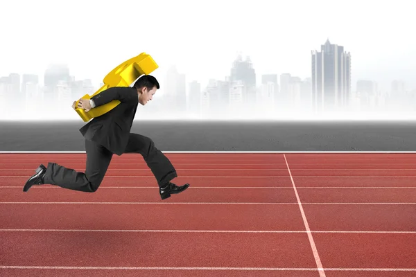 Businessman carrying golden dollar sign running on track