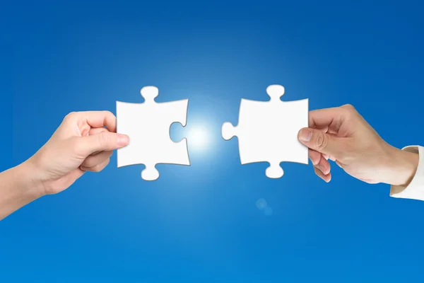 Two hands assembling jigsaw puzzle pieces — Stok fotoğraf