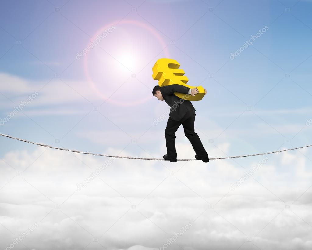 Businessman carrying golden euro sign balancing on tightrope