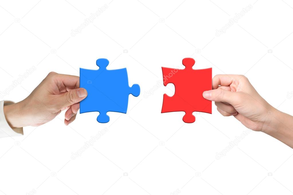 Two hands assembling jigsaw puzzle pieces