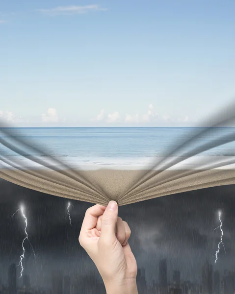 Donna mano tirando calmo spiaggia tenda che copre città tempestosa — Foto Stock