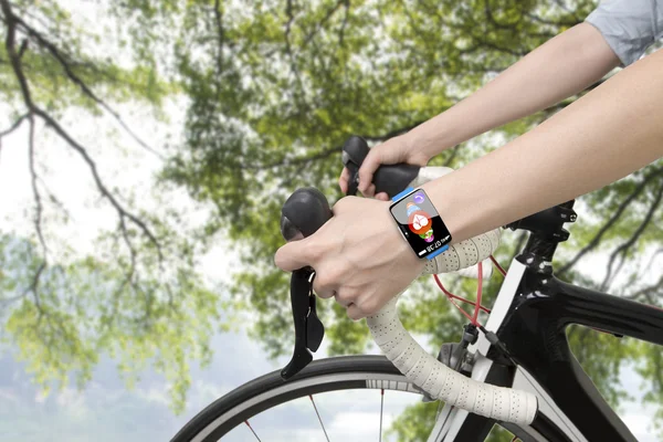 Biking woman hands wearing health sensor smart watch — Stock Photo, Image