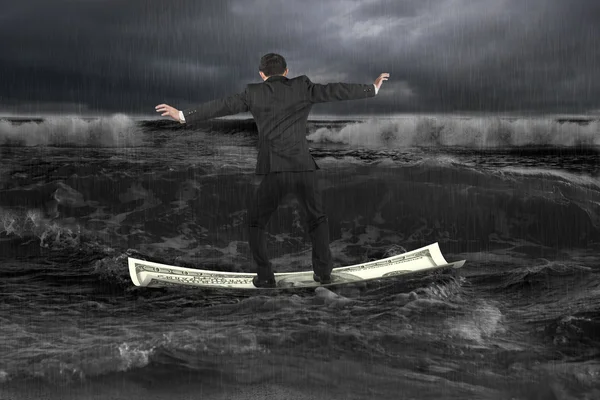 Geschäftsmann balanciert auf im Dunkeln schwimmendem Geldboot — Stockfoto