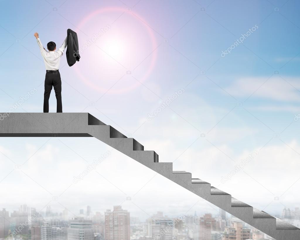 Businessman cheering on top of concrete stairs with city view