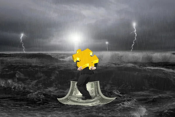 Empresário carregando quebra-cabeça de ouro 3D em barco a dinheiro com tempestade — Fotografia de Stock