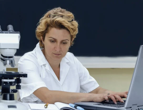 在实验室的笔记本电脑前工作的女科学家 — 图库照片