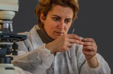 Bir kadın araştırmacının portresi. Tüpteki bir örneği analiz ediyor.