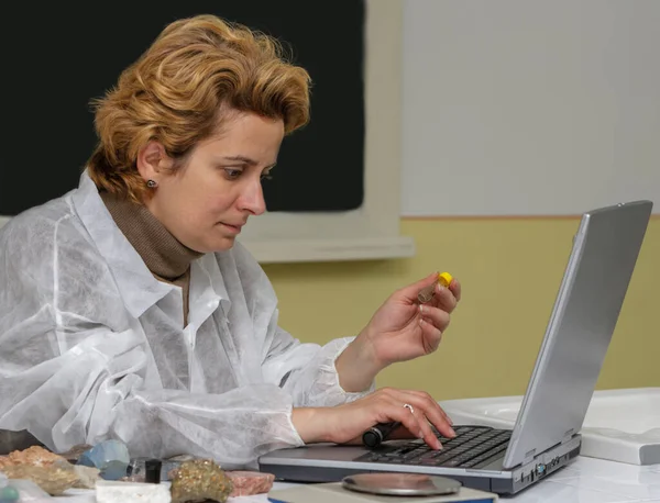 Female geologist researcher analysing a rock at her workplace.