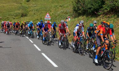 Col de la Madeleine, France - August 24, 2020: The Slovenian cyclist Tadej Pogacar (winner of Tour de France 2020) of UAE Team Emirates riding in the peloton climbing the road to Col de la Madeleine during the 3rd stage of Criterium du Dauphine 2020.