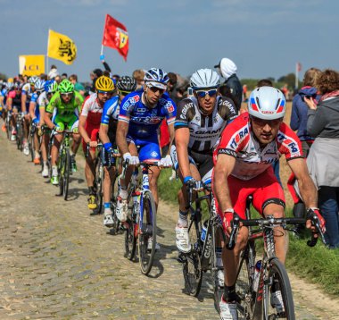 Carrefour de l 'Arbre, Fransa - 13 Nisan 2014: Paris-Roubaix bisiklet yarışı sırasında Camphin-en-Pvle kasabasındaki ünlü kaldırım taşı sektörü Carrefour de l' Arbre 'ye binen peloton.