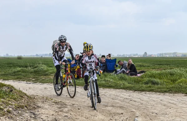 Amateur Cyclists Riding on a Cobblestoned Road