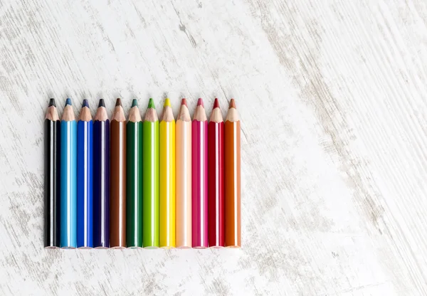 Χρωματιστά μολύβια σε ξύλινο τραπέζι — Φωτογραφία Αρχείου