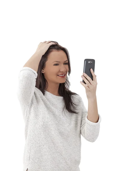 Mujer usando un Smartphone como un espejo —  Fotos de Stock