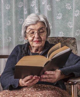 Kitap okuyan yaşlı bir kadın.