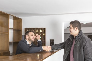 Resepsiyonist ve el sıkışan bir istemci
