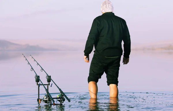 Balıkçı balıkçı oltalarla gölde balık tutuyor.