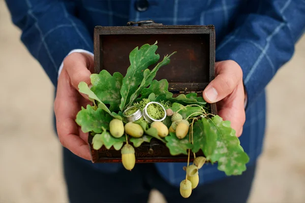 Жених держит шкатулку с золотыми обручальными кольцами — стоковое фото
