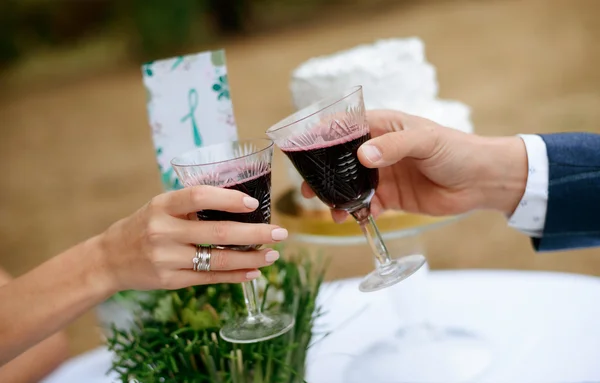 Homme et femme buvant du vin rouge. mains en gros plan avec des lunettes. Ils célèbrent leur anniversaire de mariage . — Photo