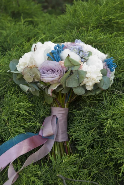 Hermoso ramo de flores blancas y azules que yacen sobre ramas verdes —  Fotos de Stock