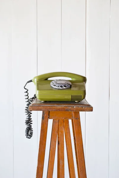 Teléfono retro giratorio sobre mesa vintage de madera. Fondo blanco — Foto de Stock