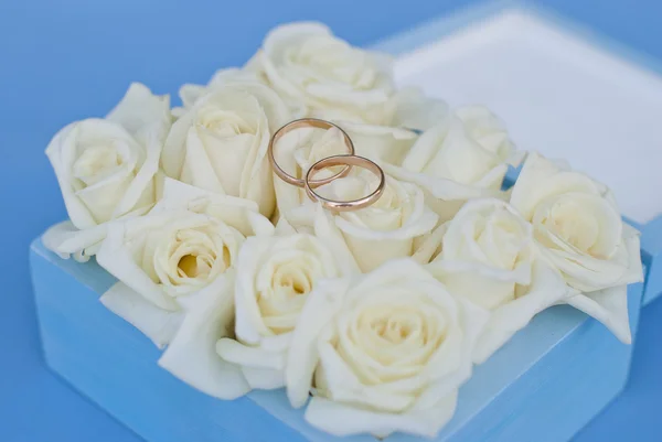 Goldene Trauringe mit weißen Rosen in der Geschenkbox — Stockfoto