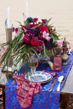 Fas stile çölde kum içinde masa aranjmanı düğün