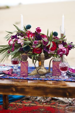 Fas stile çölde kum içinde masa aranjmanı düğün