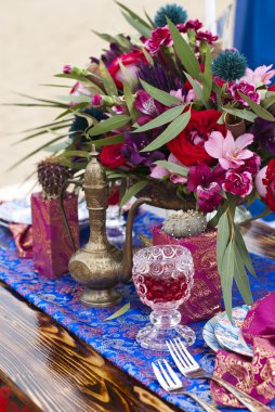 Fas stile çölde kum içinde masa aranjmanı düğün