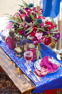 Fas stile çölde kum içinde masa aranjmanı düğün