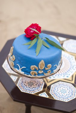 Bir tablo ve kırmızı gül çöl peyzaj üstte mavi düğün pastası