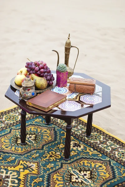 Wedding table arrangement in desert sand of Morocco stile. Fresh grapes near the salver with apples and pears — Stock Photo, Image