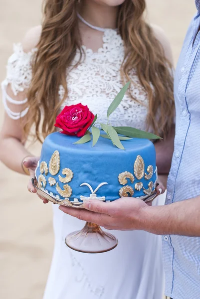 花嫁および新郎と上に赤いバラの手にブルーのウェディング ケーキ — ストック写真