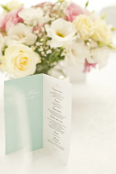 Speisekarte mit schönen Blumen auf dem Tisch am Hochzeitstag — Stockfoto