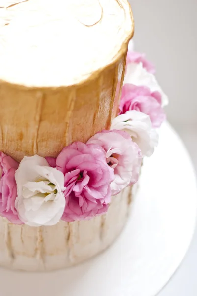 Золотой и белый свадебный торт и розовые цветы вокруг — стоковое фото
